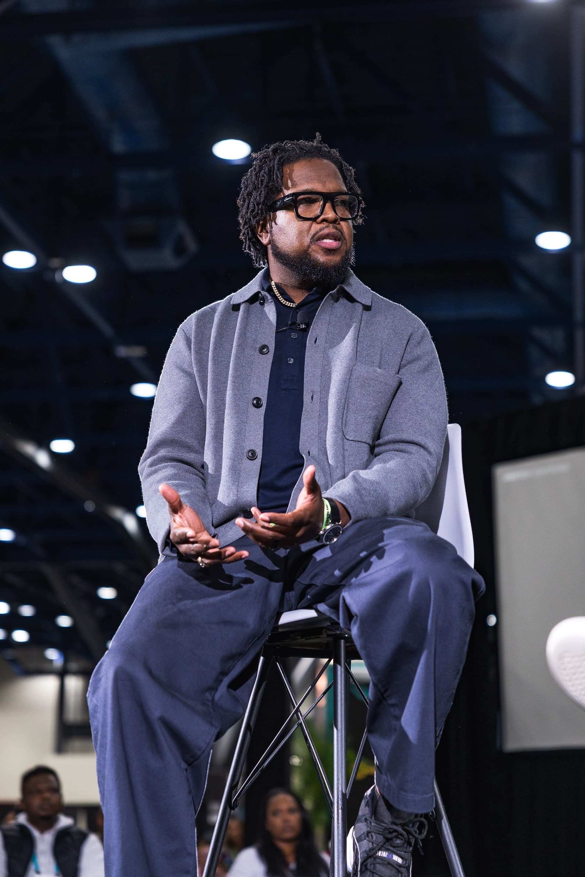 Will Lucas seated on stage at the AfroTech 2025 Apple Lab, mid-gesture as he speaks to the audience.