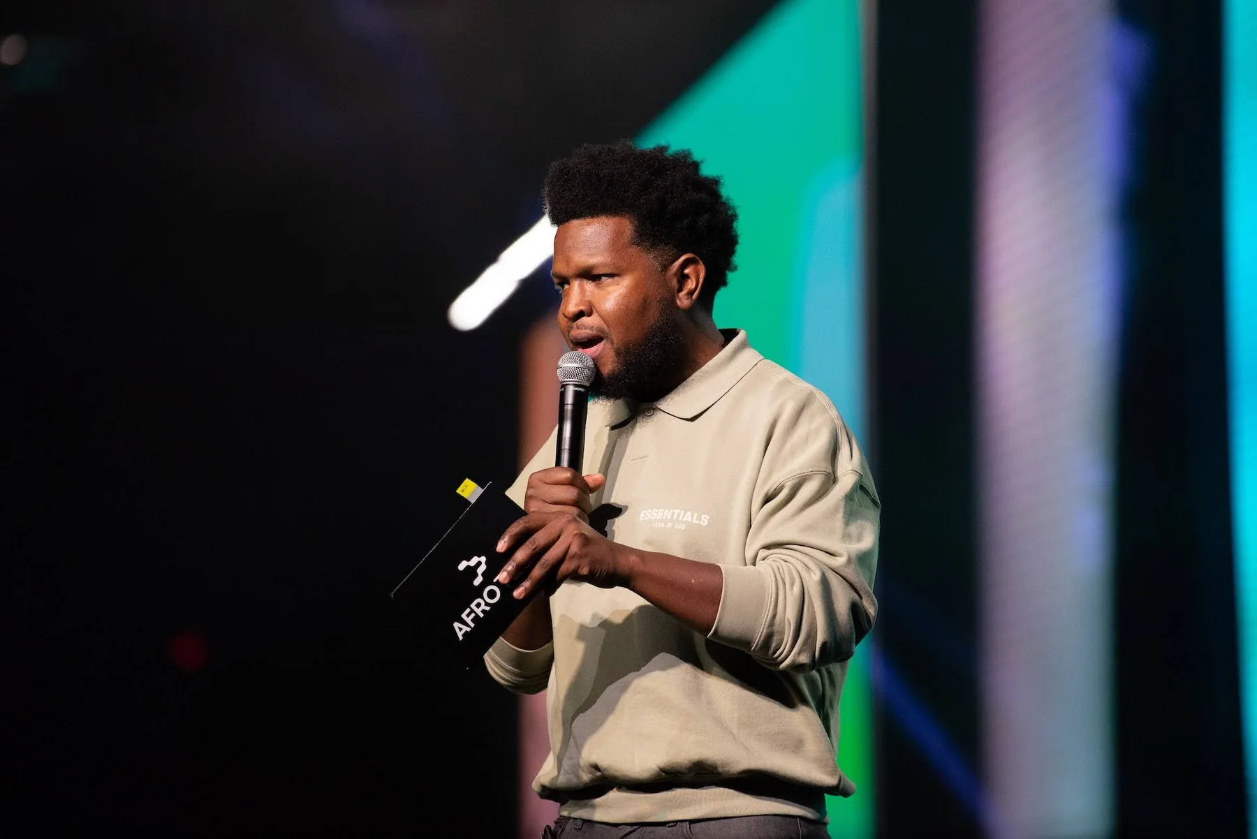Will Lucas speaking onstage at AfroTech with a microphone in hand.