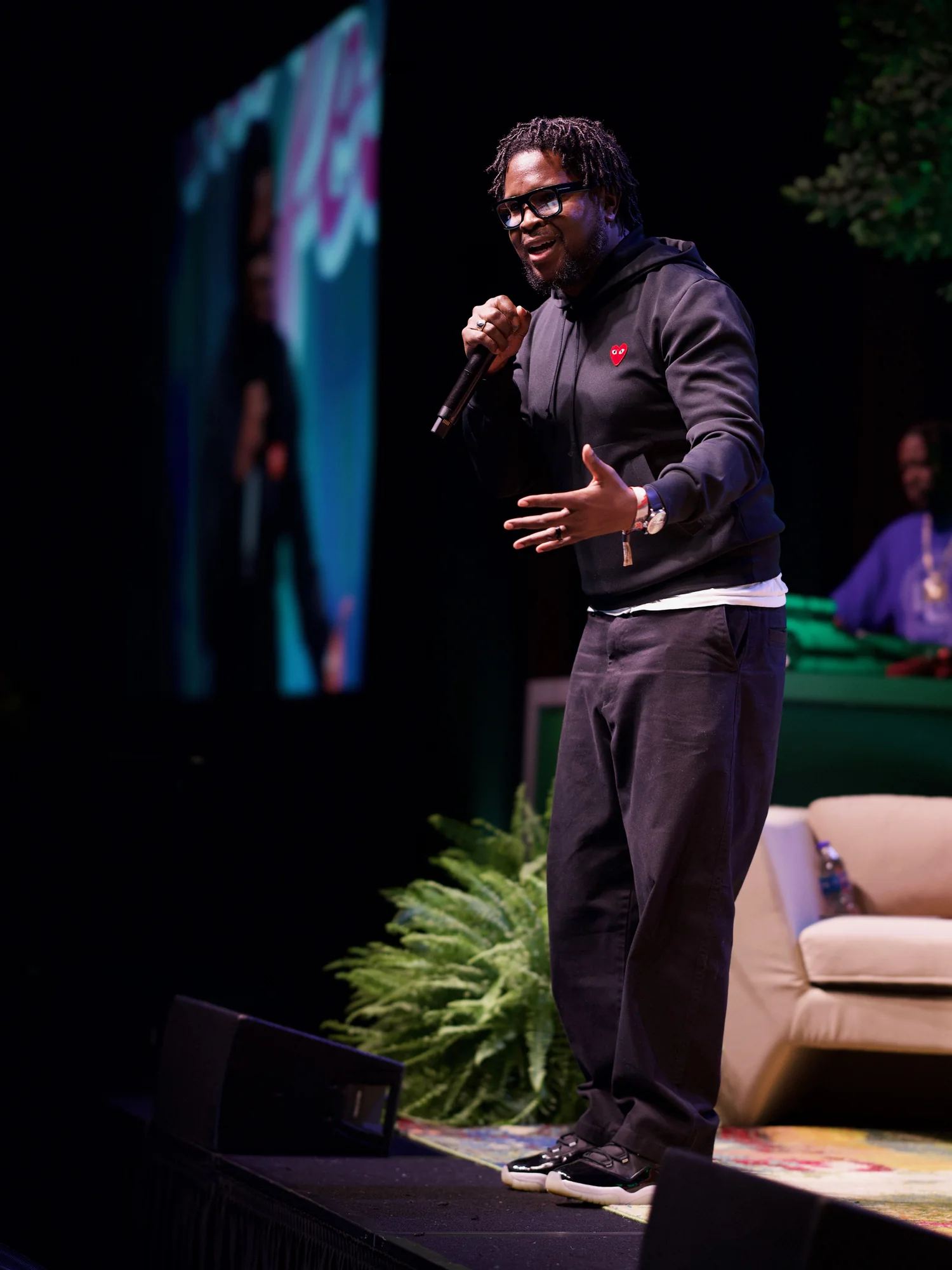 Will Lucas delivering a keynote with a handheld microphone.