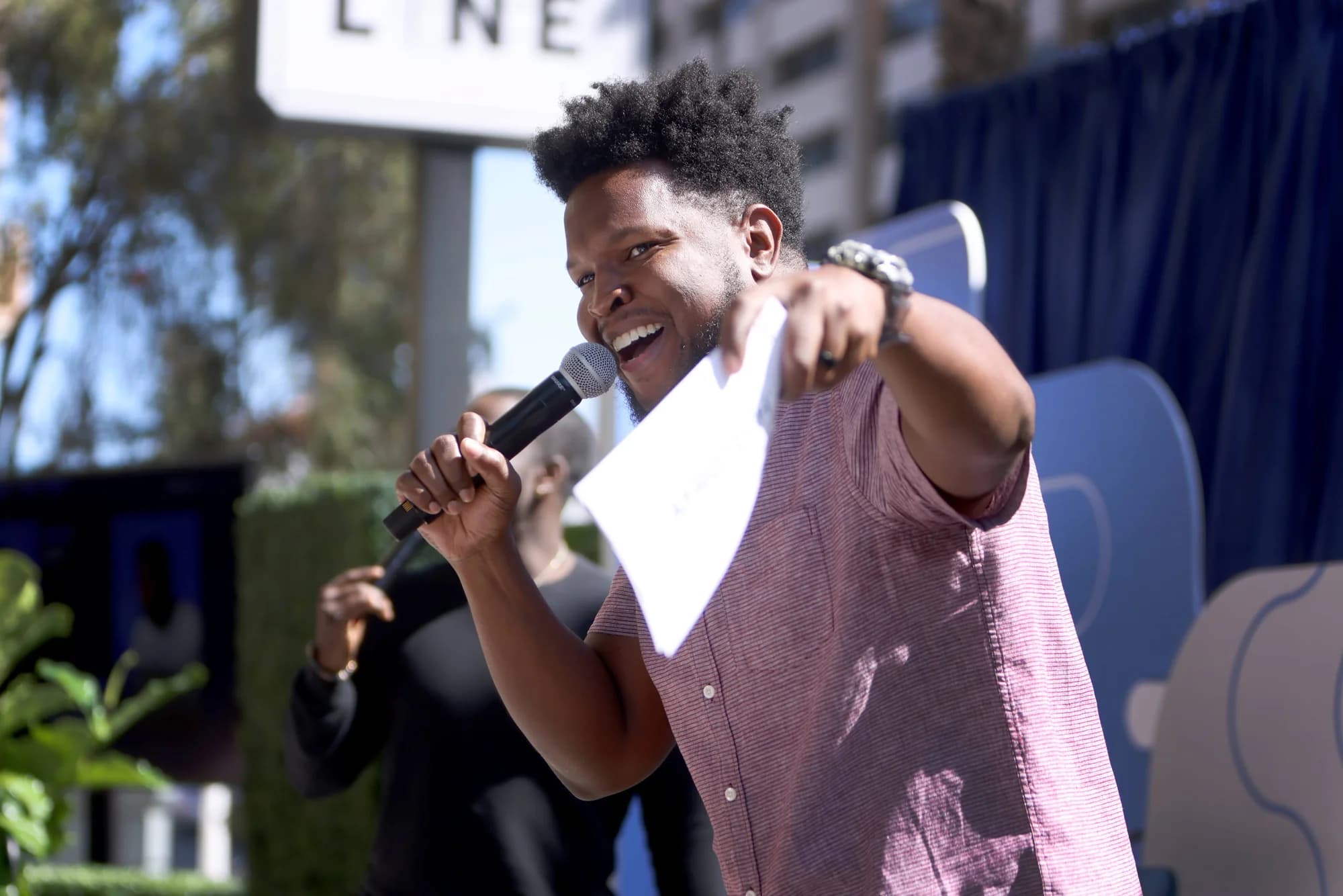 Will Lucas hosting a live outdoor event with a microphone in hand.